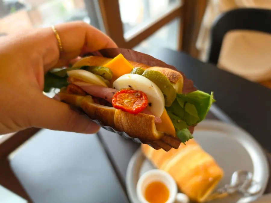 Close-up of a chimney cake sandwich with vegetables, egg and cheese