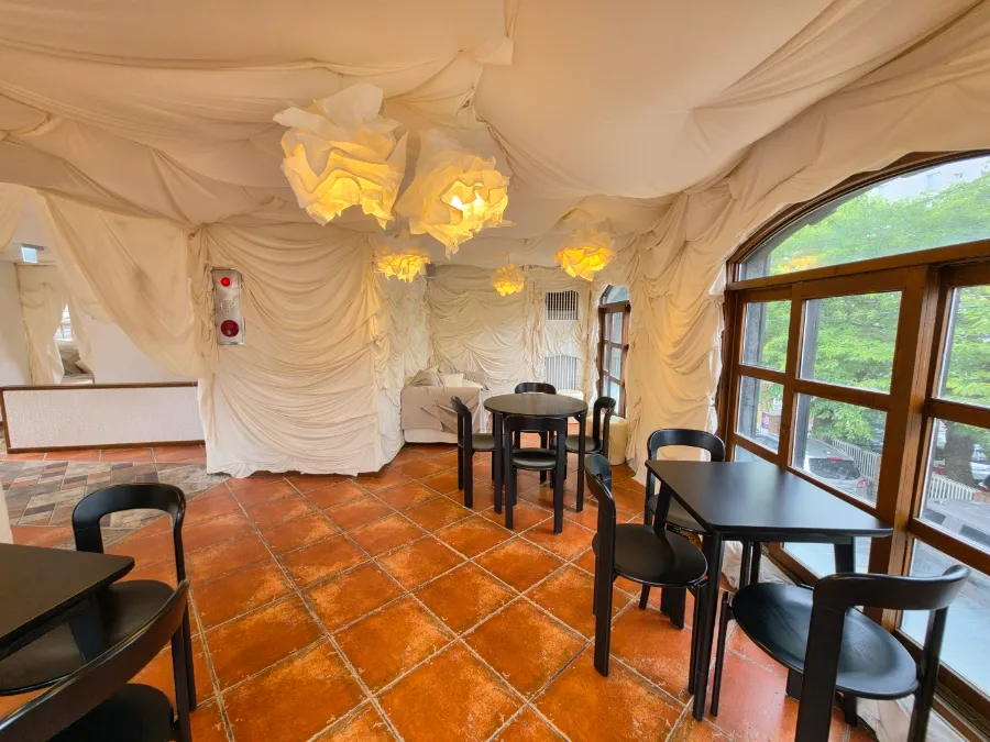 Upstairs seating with white fabric walls and large windows at Chimney Mansion