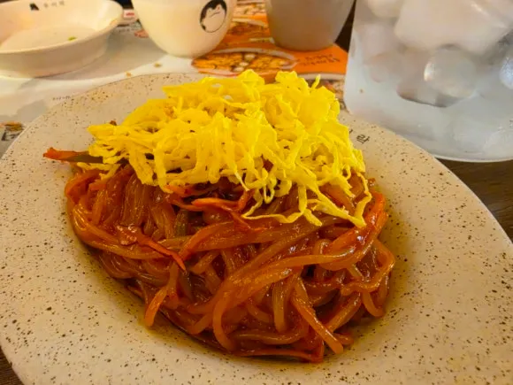 Korean jjolmyeon topped with shredded egg at Wooyirak