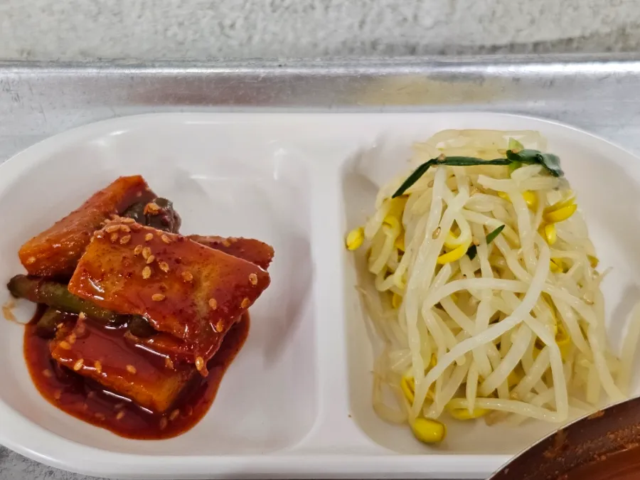 Kimchi and seasoned bean sprouts served as Korean side dishes