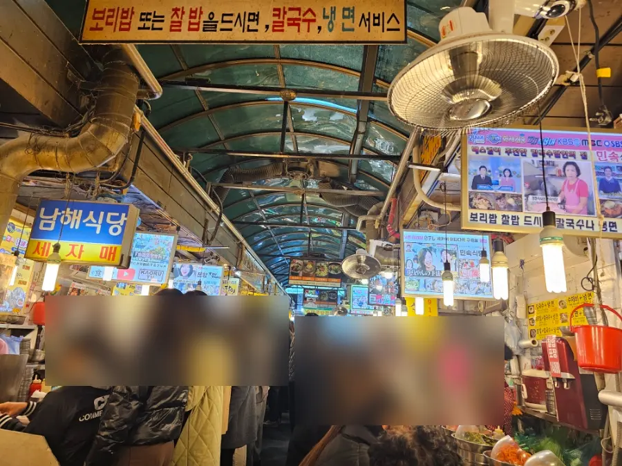 Diners seated at food stalls inside Namdaemun Market Kalguksu Alley