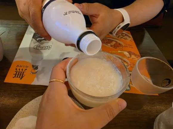 Makgeolli being poured into a bowl at Wooyirak