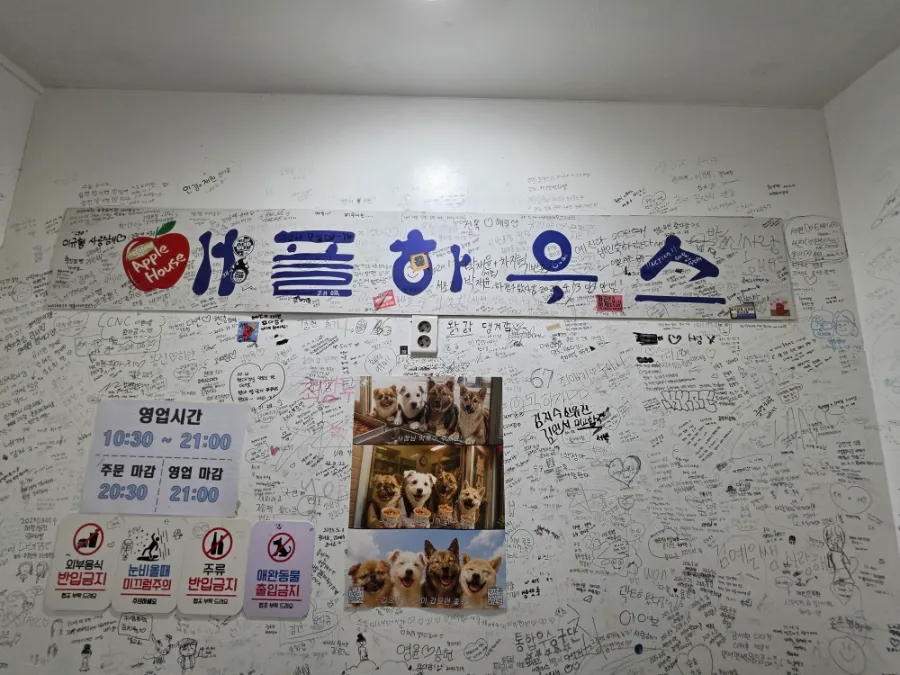 Graffiti-covered entrance to Apple House tteokbokki restaurant in Seoul