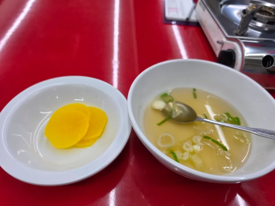 Pickled radish and soup served with tteokbokki at Apple House Seoul
