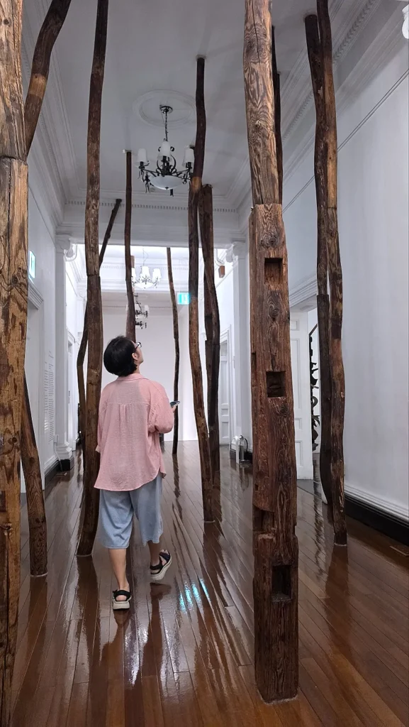 Visitor walking through Jo Sook Jin wooden installation at Nam-Seoul Museum of Art