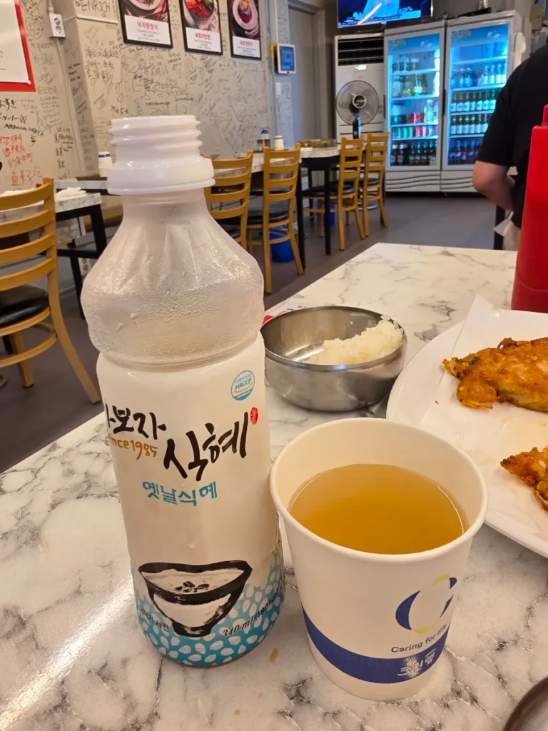 Bottle and cup of traditional Korean sikhye rice drink