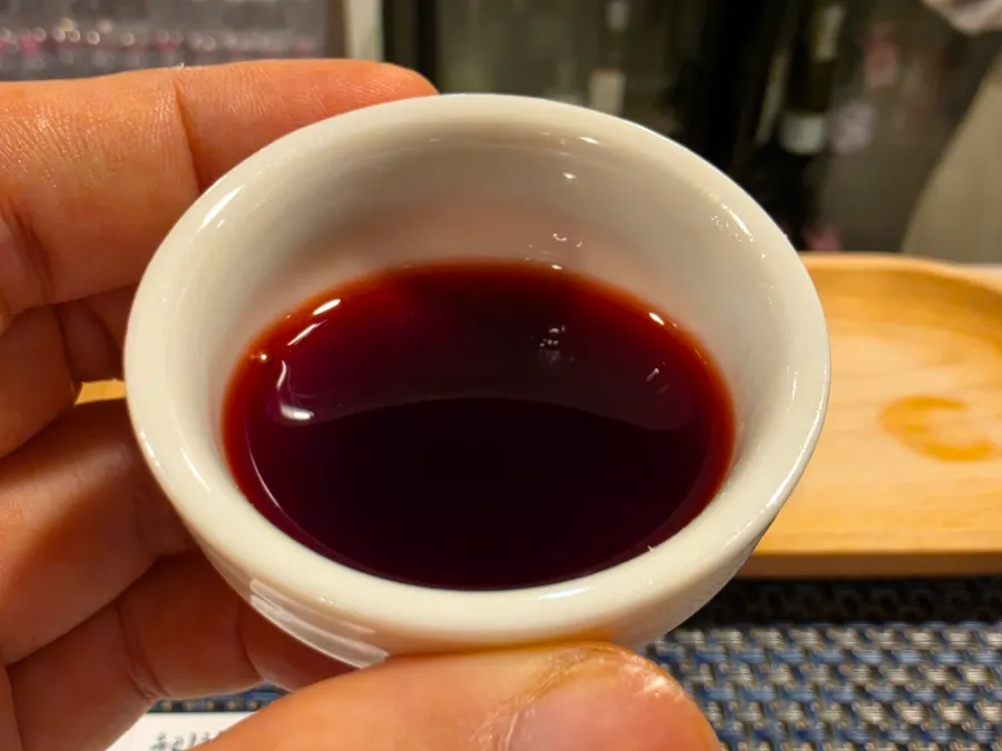 Bokdo Manchwi Korean black raspberry alcoholic drink served in a ceramic cup during a free tasting at The Sool Gallery