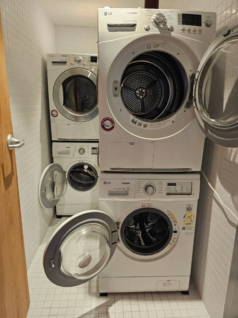 Washing machines and dryers in the shared laundry room at Local Stitch Tongyeong