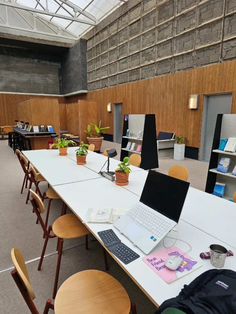 Shared workspace with a long table and chairs at Local Stitch Tongyeong